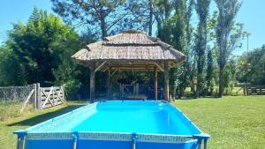 a swimming pool with a gazebo in a yard at Liland in Capilla del Señor