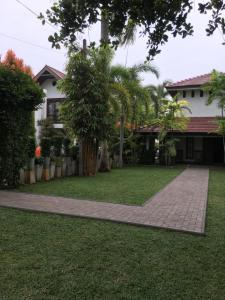 a house with a lawn and a sidewalk at Transit cabin in Seeduwa