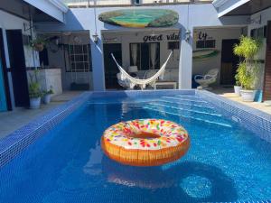a pool with a inflatable donut in the water at Hotel Perico Azul & Surf Camp in Jacó