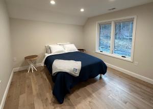 een slaapkamer met een bed met een blauwe deken en een raam bij New Farmhouse, King Beds, Game Room, Hot Tub & View! in Montgomery
