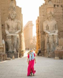 Momen Pyramids Inn في القاهرة: امرأة تمشي امام بعض التماثيل