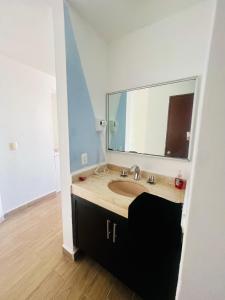a bathroom with a sink and a large mirror at Hotel Torres Gemelas 2011 N in Acapulco