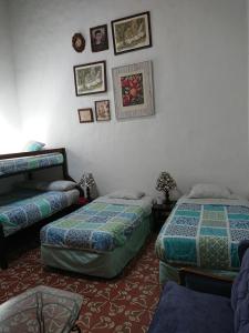 a bedroom with two beds and pictures on the wall at Suite Vintage in Puebla