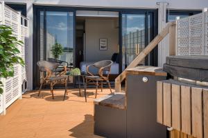 een patio met stoelen en een tafel op een balkon bij SOHO Hotel Auckland in Auckland