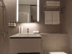 uma casa de banho com lavatório, espelho e toalhas em Hotel 1900 Chinatown em Singapura