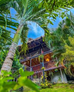 una casa con palmeras delante en Villa Tayrona en El Zaino