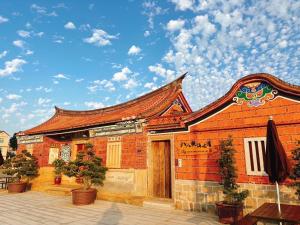 um edifício de tijolos vermelhos com telhado em Ba Ba Guan Hai Ancient House B&B em Jinsha