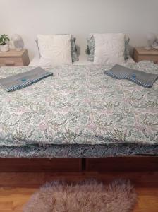 1 cama con edredón y almohadas en Apartmán Eva, en Liptovský Svätý Peter