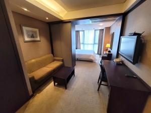 Pokój hotelowy z kanapą i telewizorem w obiekcie W Residence Hotel Centum City w Pusanie