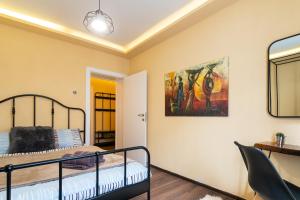 een slaapkamer met een bed en een schilderij aan de muur bij • Skopje Downtown ǀ 2 Bedrooms ǀ Parking • in Skopje