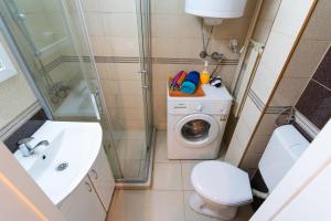 een kleine badkamer met een wasmachine en een wasmachine bij • Skopje Downtown ǀ 2 Bedrooms ǀ Parking • in Skopje