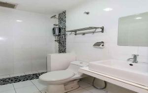 a white bathroom with a toilet and a sink at Smile Hotel Shah Alam ICity in Shah Alam