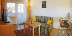 ein Wohnzimmer mit einem Sofa und einem Tisch in der Unterkunft Appartement Werner Hauptenbuchner in Bad Füssing