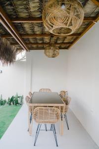 a table with wicker chairs and a ceiling at Private Villa with Pool in Vigan, Ilocos Sur - Selene Private Villas in San Vincente