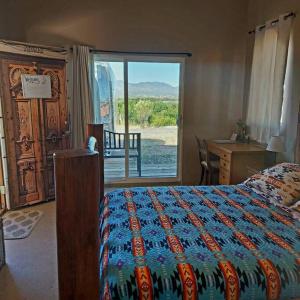 a bedroom with a bed and a desk and a window at Stargazing Retreats in Camp Verde