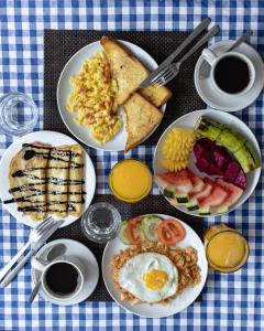 a table topped with plates of breakfast foods and coffee at Gili Ocean Club - ADULTS ONLY in Gili Trawangan