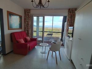 uma sala de estar com um sofá vermelho e uma mesa e cadeiras em Appartement Argelès-sur-Mer, 1 pièce, 4 personnes - FR-1-776-39 em Argelès-sur-Mer