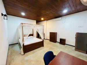 Cette chambre comprend un lit et une table. dans l'établissement Hari Villa Mirissa, à Mirissa