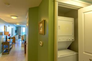 a kitchen with green walls and a white refrigerator at Waterscape C605 - Top Floor Beach Views - Free Beach Service - Interior Facing! in Fort Walton Beach