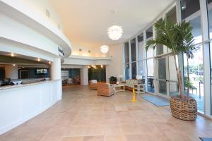 a lobby with a palm tree in a building at Waterscape C605 - Top Floor Beach Views - Free Beach Service - Interior Facing! in Fort Walton Beach +35 photos