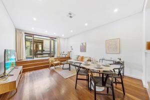 sala de estar con mesa, sillas y sofá en Escape To Sydney @ Ultimo Unique 2 Bedroom Sleeping 7 City Side en Sídney