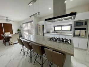 a kitchen with a counter with chairs around it at Casa Santacruz in Ensenada