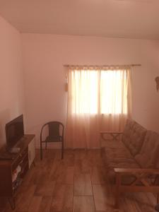 a living room with a couch and a television at Casita colonia in Colonia del Sacramento