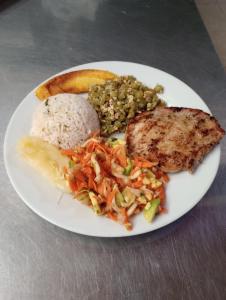 a plate of food with rice and meat and vegetables at Hotel Bethesda in Aguachica