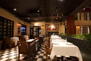 a dining room with tables and chairs in a restaurant at La Chronique Hotel in Phnom Penh