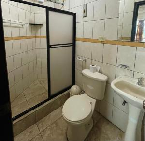 a bathroom with a toilet and a sink at Hotel Río Tena in Tena