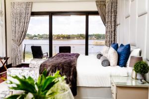 a bedroom with a bed and a large window at One O Eight Boutique Hotel in Benoni