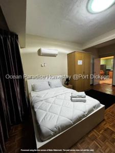 een slaapkamer met een groot bed met witte lakens bij Ocean Paradise homestay @ port dickson in Port Dickson