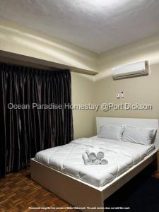 - une chambre avec un lit doté de draps blancs et une fenêtre dans l'établissement Ocean Paradise homestay @ port dickson, à Port Dickson