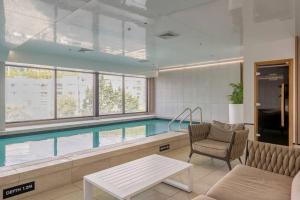 een zwembad in een kamer met een bank en een stoel bij CBD Apartment beside Millennium in Auckland