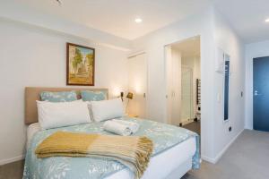 a bedroom with a bed with a blanket on it at CBD Apartment beside Millennium in Auckland +25 photos