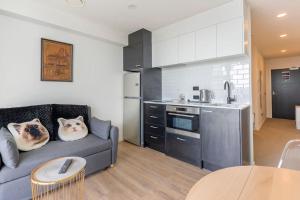 een woonkamer met een bank en een keuken bij CBD Apartment beside Millennium in Auckland