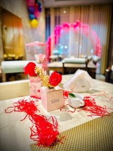 a table with red flowers and a sign that says love at Garden City Hotel Dubai in Dubai