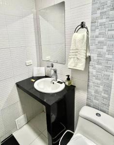 a bathroom with a sink and a toilet and a mirror at TRÉBOL GOLDEN HOTEL in Ipiales