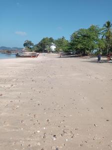 a sandy beach with footprints in the sand at Bangkaew Camping place bangalow in Krabi town