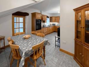 a kitchen with a table and chairs and a table and a kitchen at Glanllyn Lodge in Llanuwchllyn