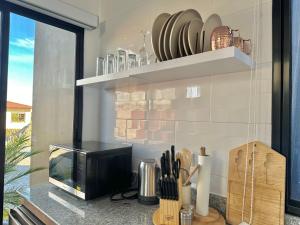 a kitchen with a counter with a tv and a window at Cabañas y suites Sunset in Alto Boquete +16 photos