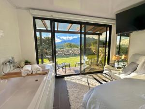 a bedroom with a bed and a large glass window at Cabañas y suites Sunset in Alto Boquete