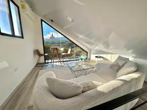 - un salon avec un canapé et une grande fenêtre dans l'établissement Cabañas y suites Sunset, à Alto Boquete
