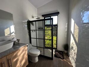 a bathroom with a toilet and a window at Cabañas y suites Sunset in Alto Boquete