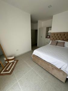 a bedroom with a large bed and a tiled floor at Punta Blanca Apt in Punta Blanca