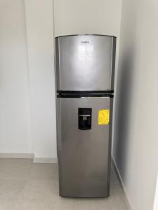 a stainless steel refrigerator with a yellow sign on it at Punta Blanca Apt in Punta Blanca