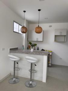 a kitchen with a counter and two stools at Punta Blanca Apt in Punta Blanca