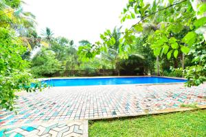 a swimming pool in the middle of a yard at Ariya Rest & Ayurveda spa in Polonnaruwa