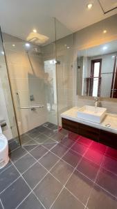 La salle de bains est pourvue d'un lavabo et d'une douche en verre. dans l'établissement Căn hộ hiện đại, à Quy Nhơn