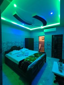 1 dormitorio con 1 cama con luz azul en Hotel Paradise, en Mandarmani